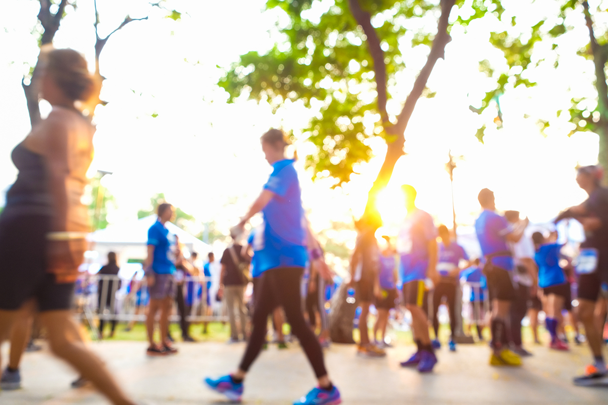 Group of people running in public city park